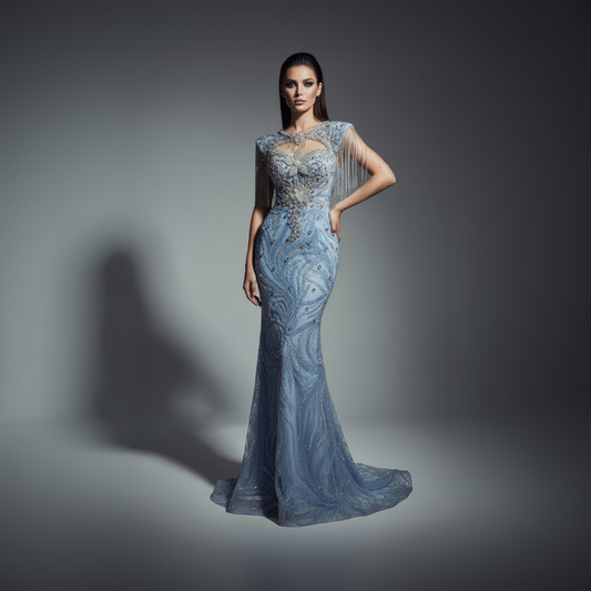 Woman wearing a blue evening gown with intricate detailing on a gray background