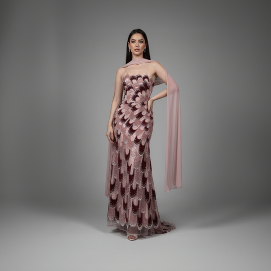 Woman wearing a pink floral dress with a matching shawl against a gray background