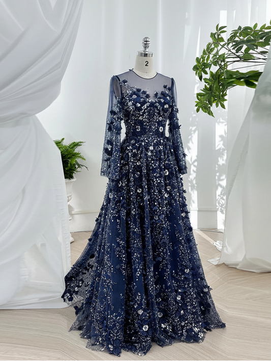 Navy blue evening gown with floral embellishments on a mannequin against a white curtain background.