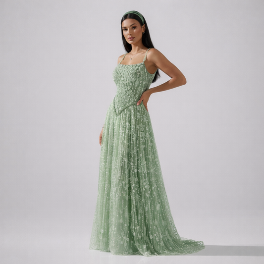 Woman wearing a green evening gown against a plain background