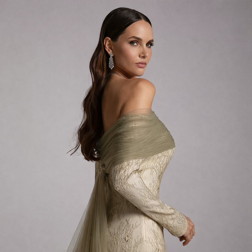 Woman wearing a elegant off-shoulder dress with lace details on a gray background