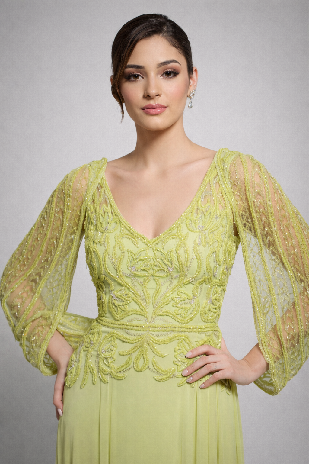 Woman wearing a green lace dress against a gray background