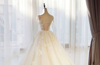 Elegant beige evening gown on a mannequin against a soft, blurred background