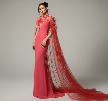 Woman wearing a pink floral dress with a matching floral shawl against a gray background