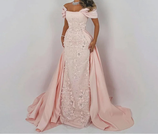 Woman wearing a pink and white evening gown with floral details on a plain background, branded 'Eshault & Bridal'.