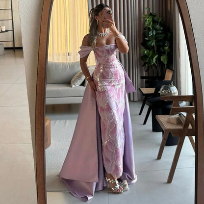 Woman in a pink and purple evening gown taking a mirror selfie in a stylish room.