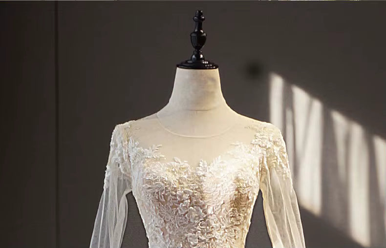 White lace dress on a mannequin against a dark background
