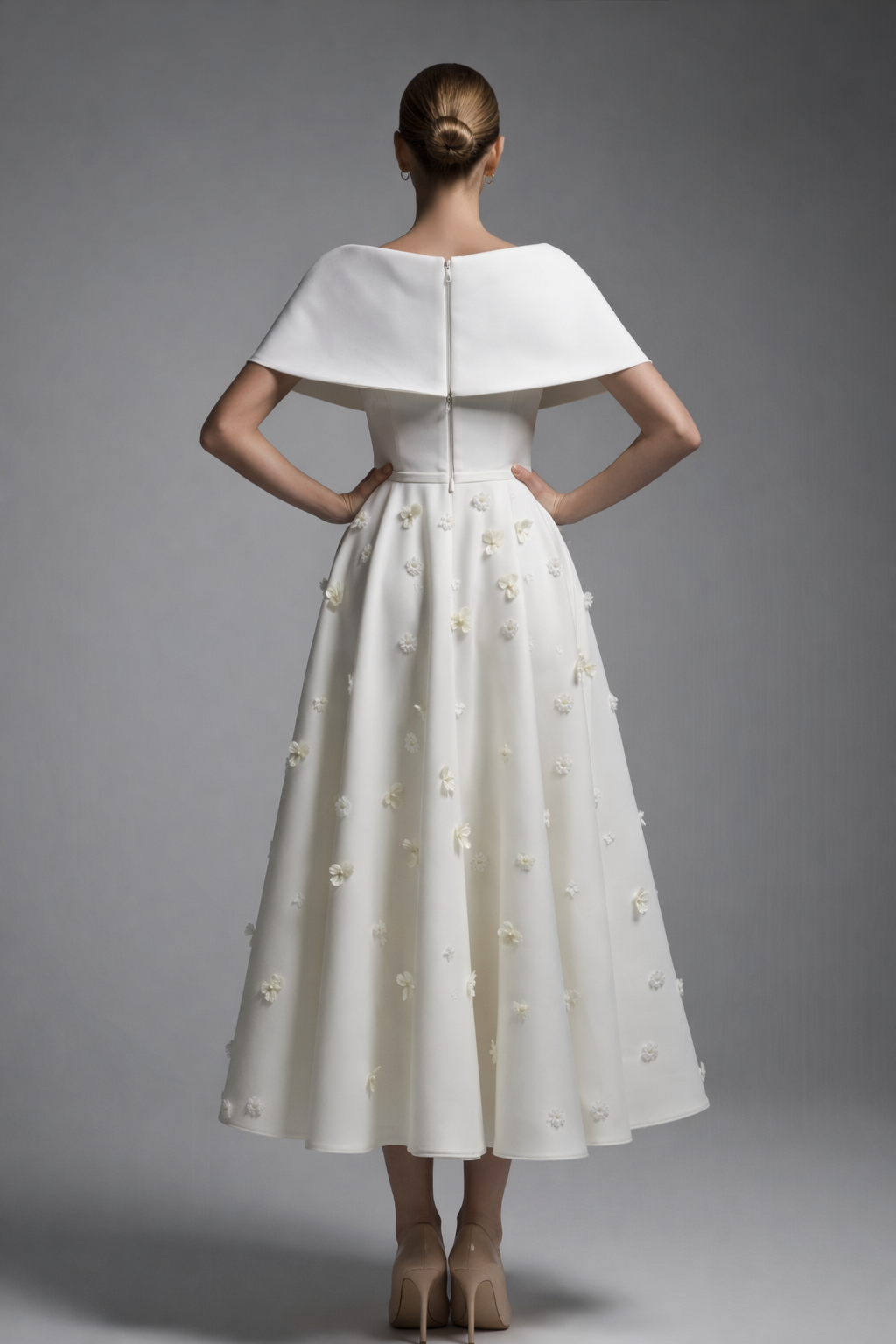 White dress with a capelet on a gray background